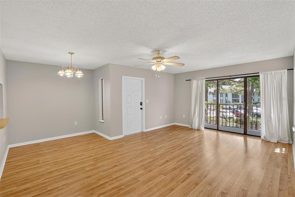 1225 Pine Ridge Circle West, Unit A2 Tarpon Springs, FL 34688 - Photo 14 of 59 a view of an empty room with wooden floor and a window