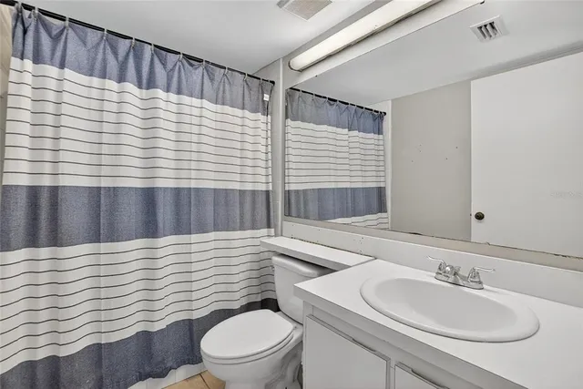 a view of an empty room with wooden floor and a ceiling fan