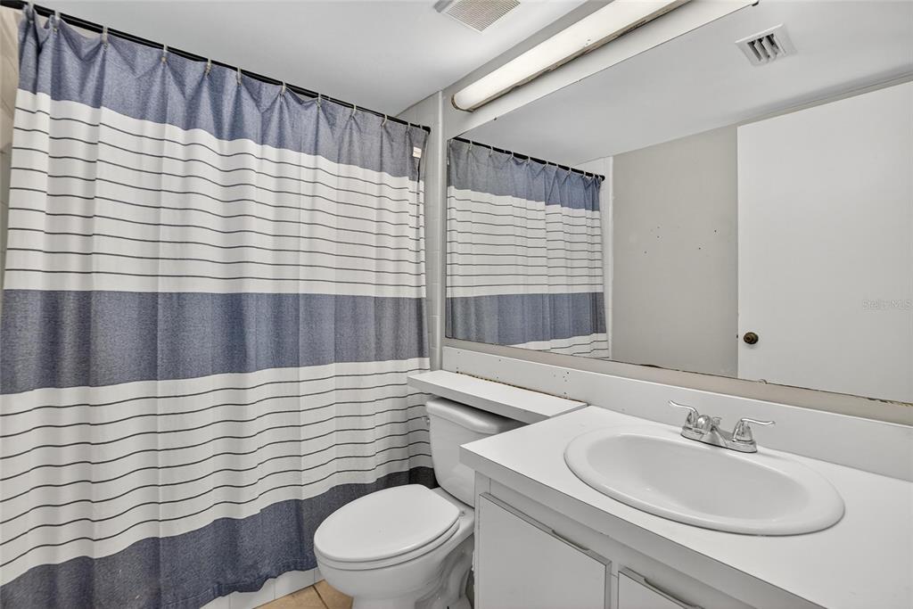 1225 Pine Ridge Circle West, Unit A2 Tarpon Springs, FL 34688 - Photo 19 of 59 a bathroom with a sink a toilet and mirror