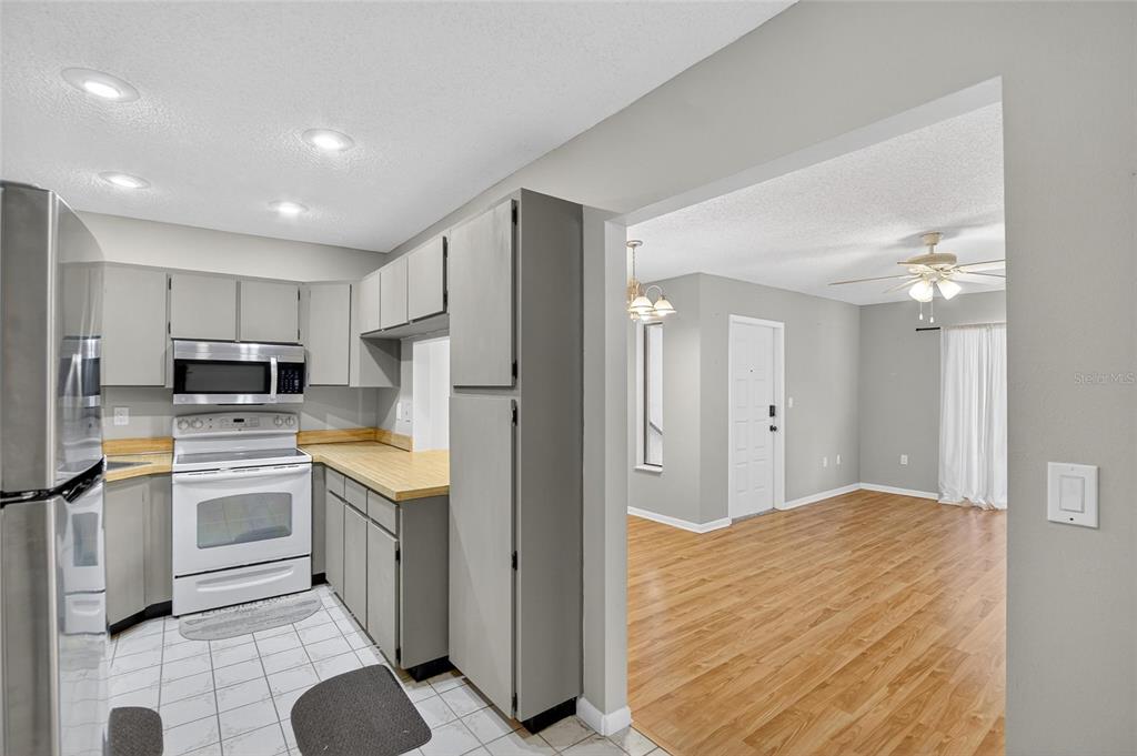 1225 Pine Ridge Circle West, Unit A2 Tarpon Springs, FL 34688 - Photo 21 of 59 a kitchen with stainless steel appliances granite countertop a refrigerator and a stove top oven