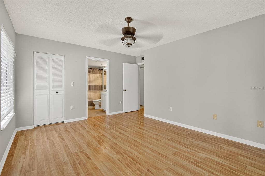 1225 Pine Ridge Circle West, Unit A2 Tarpon Springs, FL 34688 - Photo 24 of 59 a view of an empty room with wooden floor and a window