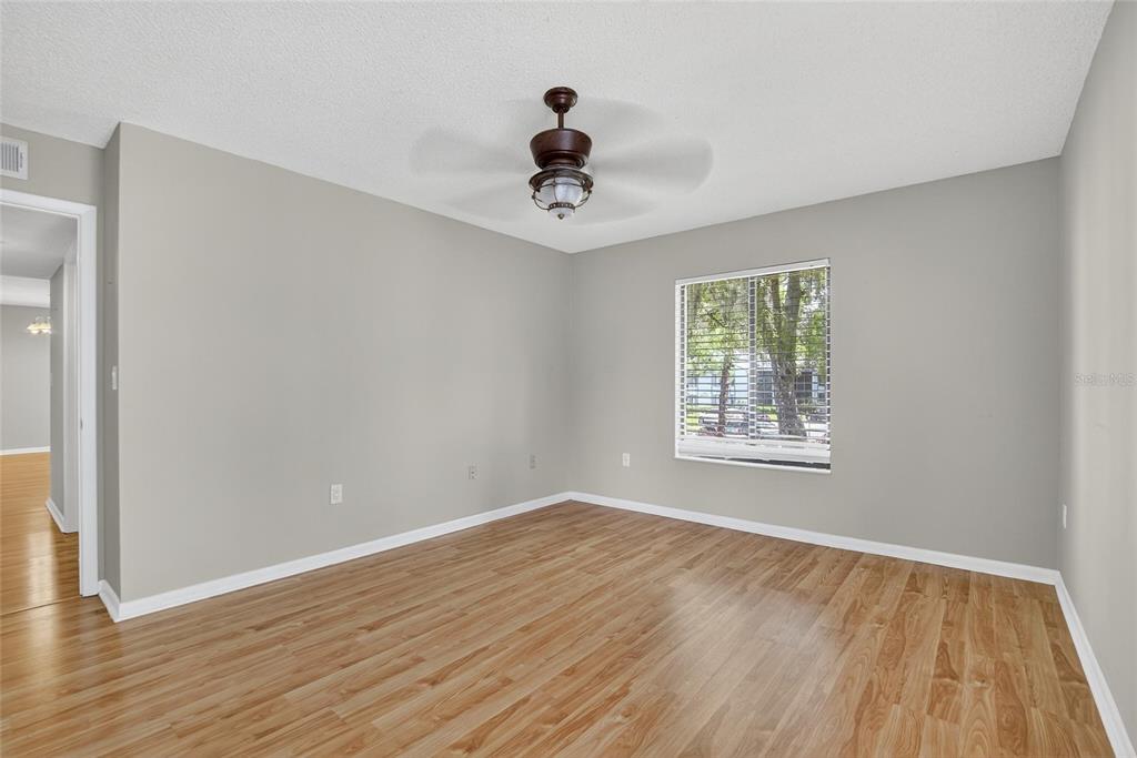 1225 Pine Ridge Circle West, Unit A2 Tarpon Springs, FL 34688 - Photo 25 of 59 a view of an empty room with wooden floor and a window