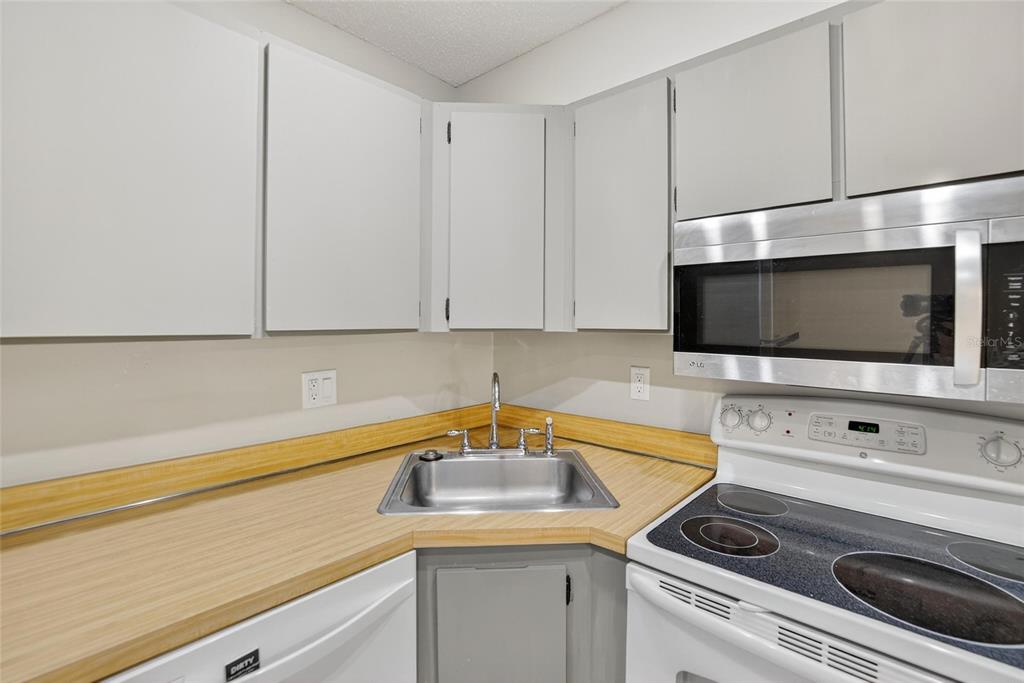 1225 Pine Ridge Circle West, Unit A2 Tarpon Springs, FL 34688 - Photo 38 of 59 a kitchen with a stove microwave and sink
