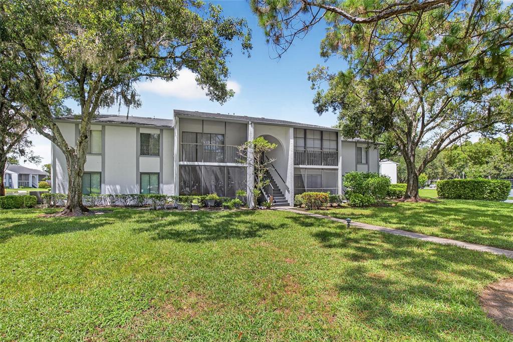 1225 Pine Ridge Circle West, Unit A2 Tarpon Springs, FL 34688 - Photo 4 of 59 front view of a house with a yard