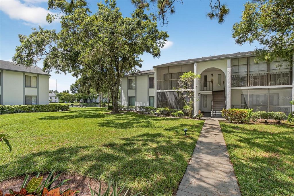 1225 Pine Ridge Circle West, Unit A2 Tarpon Springs, FL 34688 - Photo 6 of 59 a front view of a house with a yard