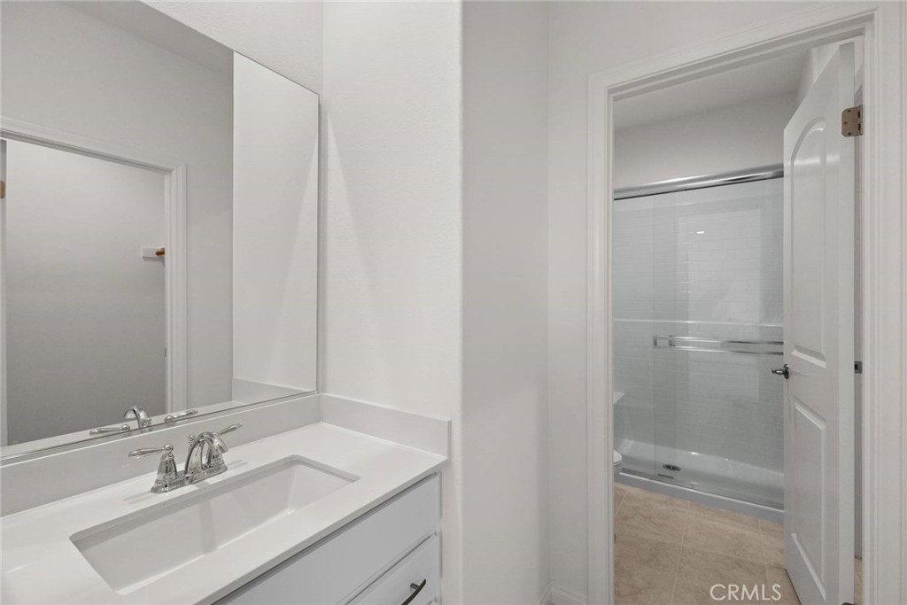 17727 Santa Lucia Court Riverside, CA 92503 - Photo 21 of 42 a bathroom with a sink a mirror and shower