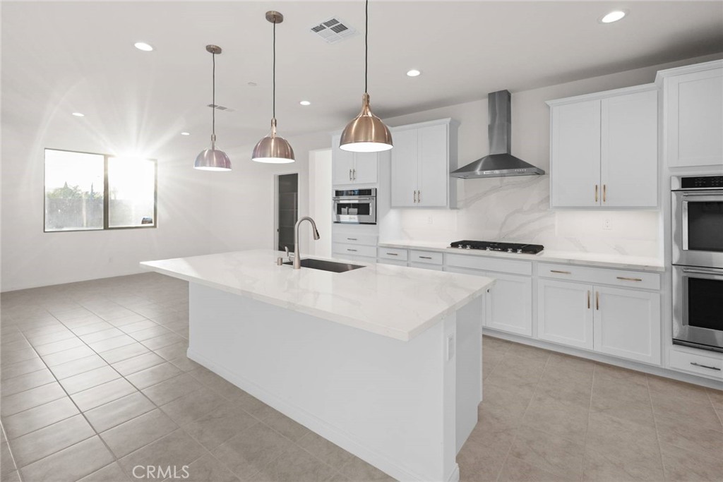 17727 Santa Lucia Court Riverside, CA 92503 - Photo 3 of 42 a kitchen with stainless steel appliances kitchen island granite countertop a sink a stove a refrigerator and white cabinets