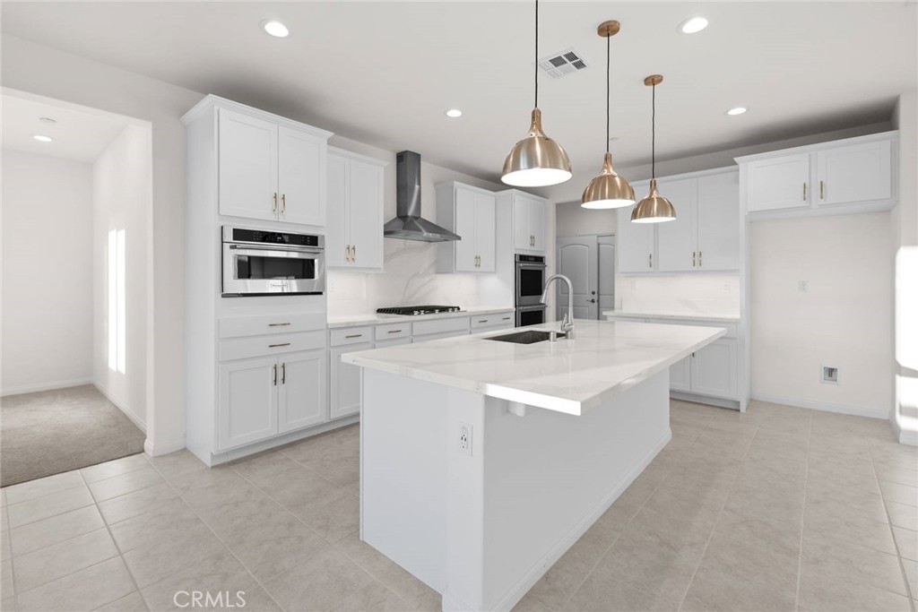 17727 Santa Lucia Court Riverside, CA 92503 - Photo 4 of 42 a kitchen with kitchen island a white counter top space a sink and a stove