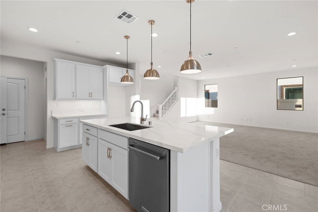 17727 Santa Lucia Court Riverside, CA 92503 - Photo 5 of 42 a kitchen with a sink a stove a refrigerator and white cabinets