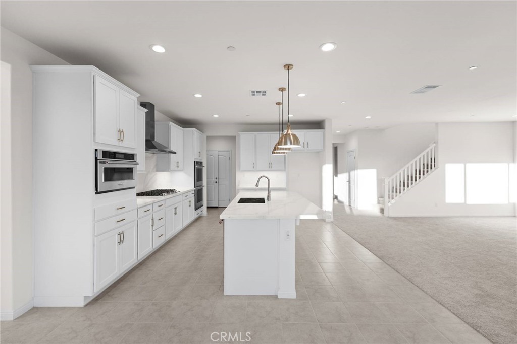 17727 Santa Lucia Court Riverside, CA 92503 - Photo 10 of 42 a large kitchen with stainless steel appliances kitchen island a stove a sink a refrigerator and a cabinets