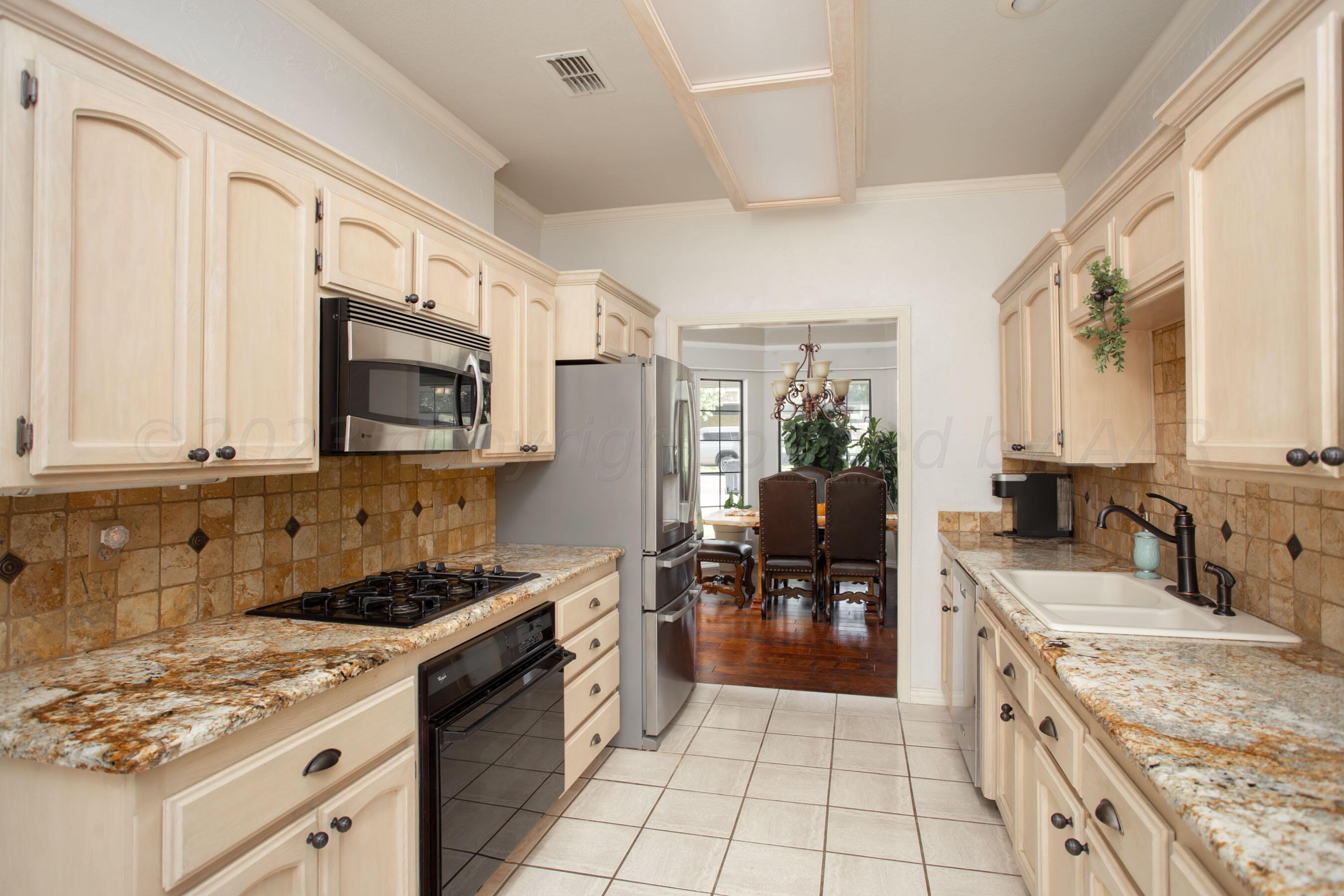 7301 Smoketree Drive Amarillo, TX 79124 - Photo 11 of 37 a kitchen with a stove a sink and a refrigerator