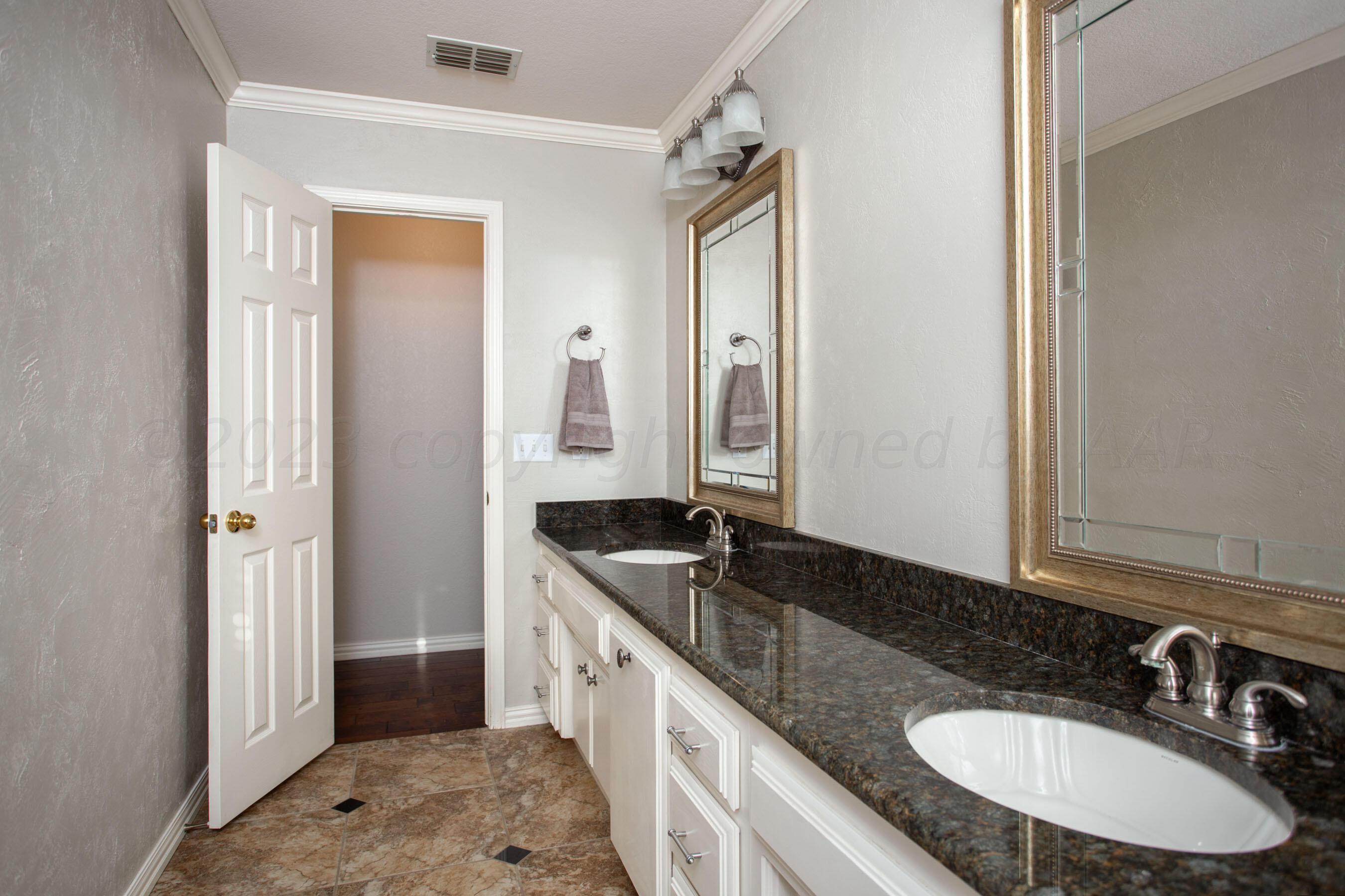 7301 Smoketree Drive Amarillo, TX 79124 - Photo 27 of 37 a bathroom with a granite countertop sink and a mirror