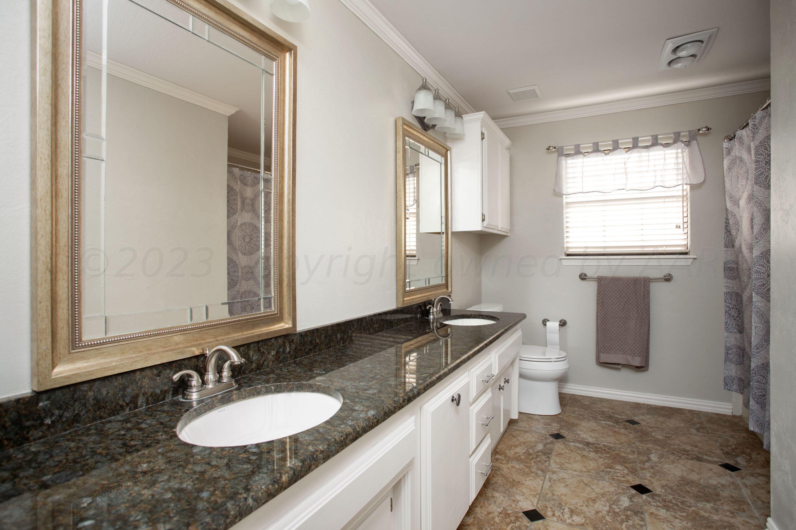 7301 Smoketree Drive Amarillo, TX 79124 - Photo 28 of 37 a bathroom with a granite countertop sink and a mirror