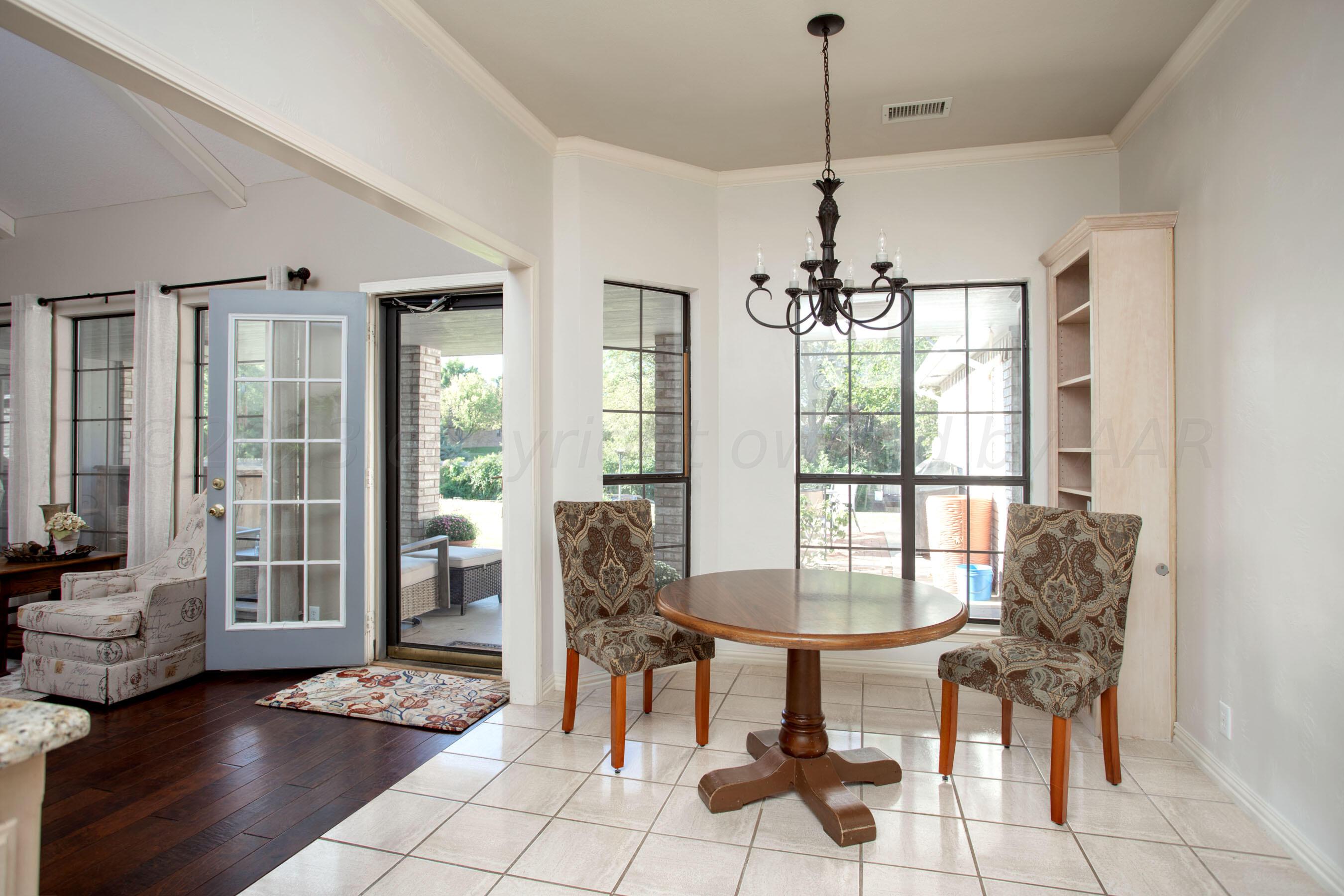 7301 Smoketree Drive Amarillo, TX 79124 - Photo 10 of 37 a dining room with furniture a chandelier and wooden floor