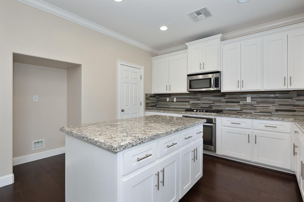 1916 Hartsfield Way Lincoln, CA 95648 - Photo 12 of 35 a kitchen with granite countertop a sink stove and white cabinets
