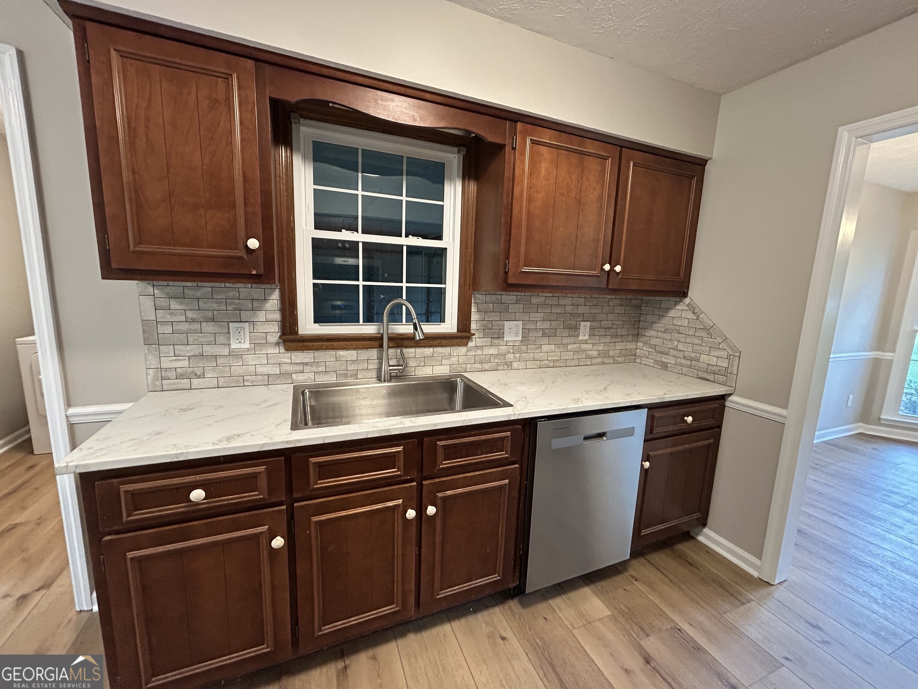 191 Moccasin Trail LaGrange, GA 30241 - Photo 16 of 32 a kitchen with stainless steel appliances granite countertop wooden cabinets a sink and dishwasher with wooden floor