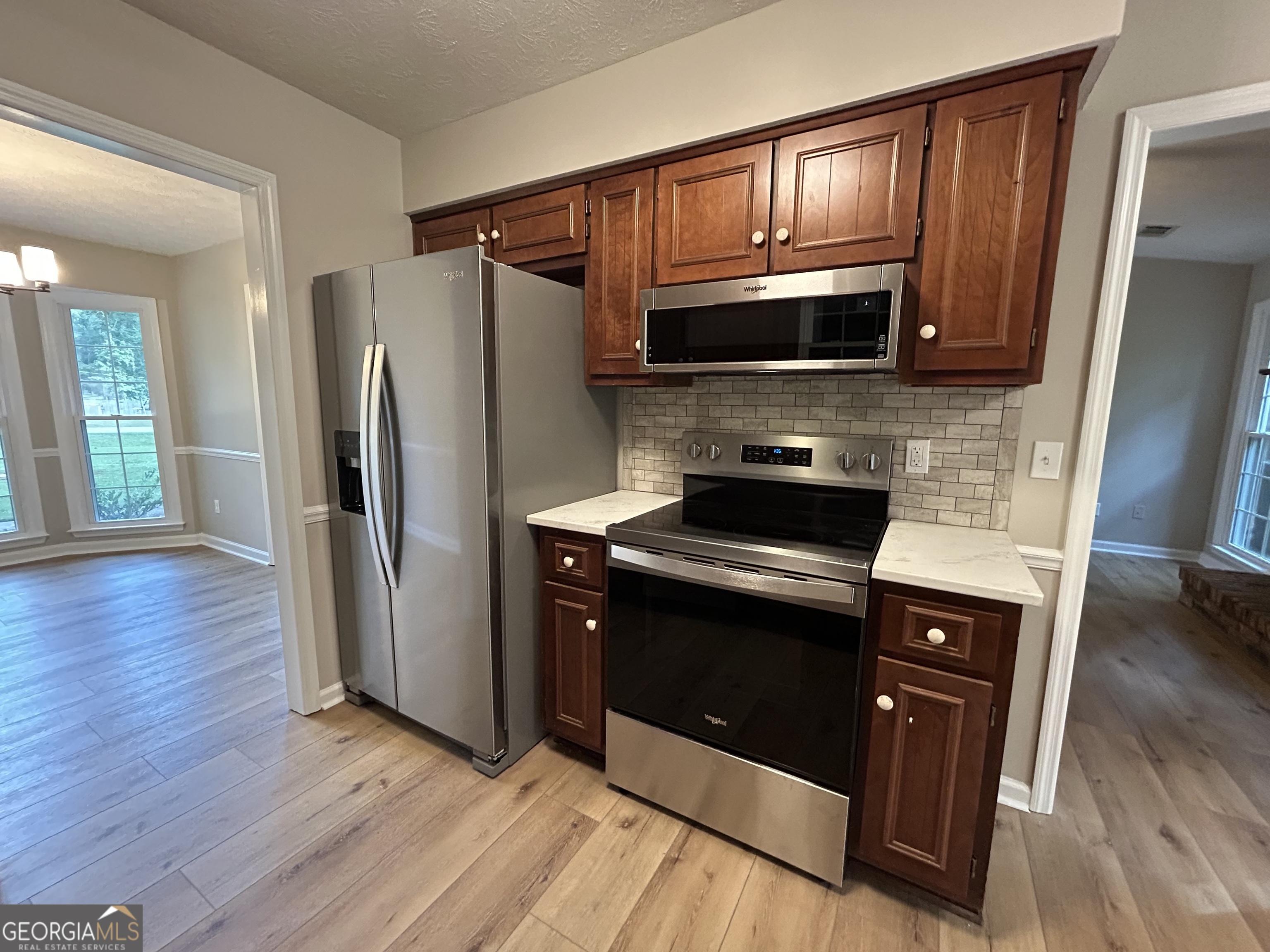 191 Moccasin Trail LaGrange, GA 30241 - Photo 17 of 32 a kitchen with wooden floors and stainless steel appliances