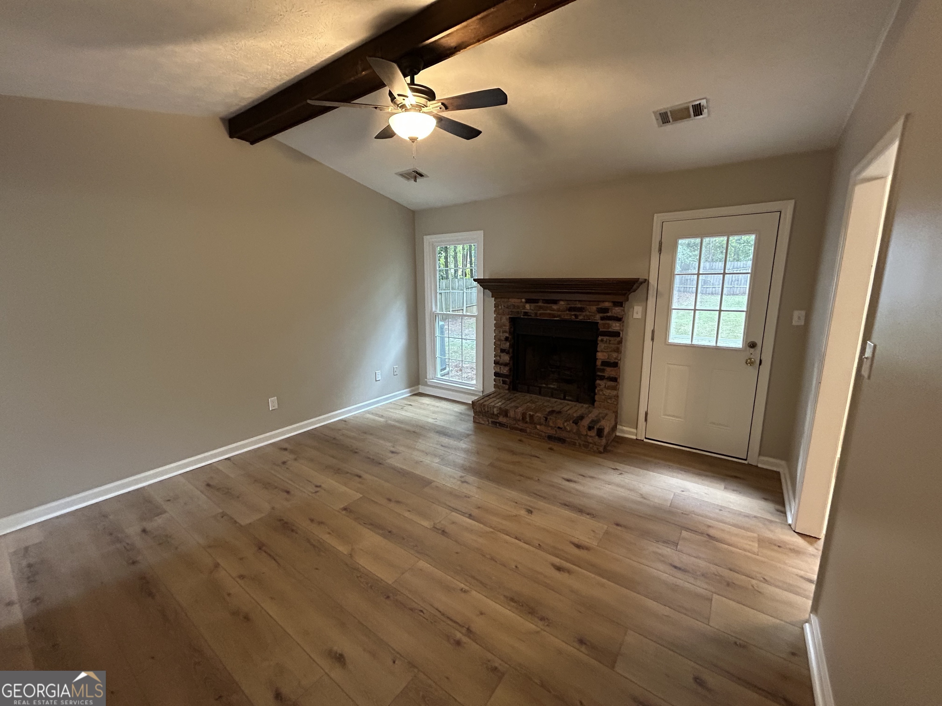 191 Moccasin Trail LaGrange, GA 30241 - Photo 6 of 32 an empty room with windows fireplace and fan
