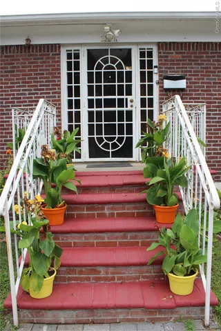 a front view of a house with a yard potted plants