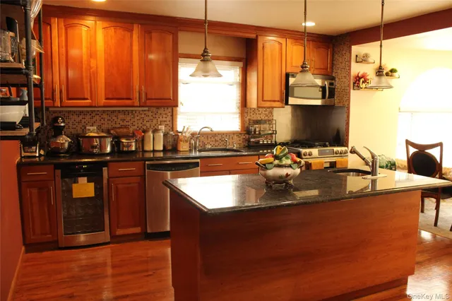 a kitchen with stainless steel appliances granite countertop a sink a stove and a refrigerator