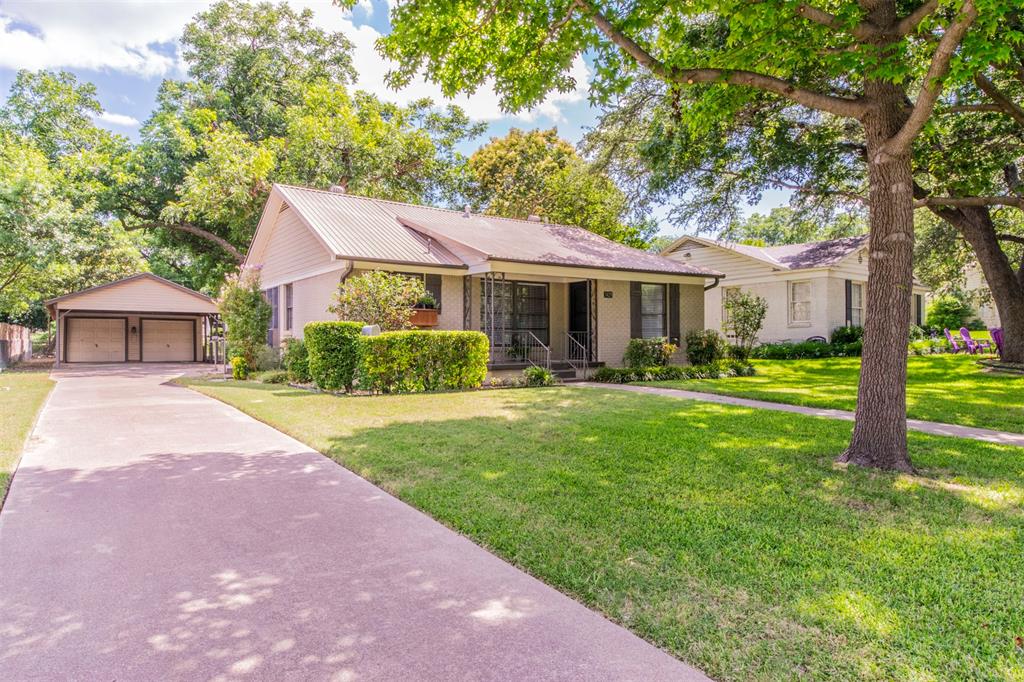 a front view of a house with a yard and trees
