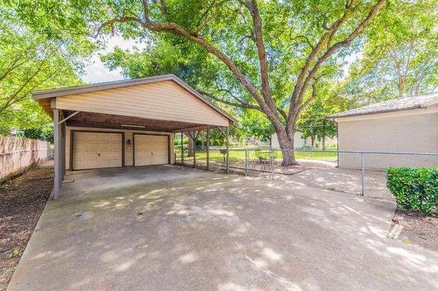 a view of a house with a yard and large tree