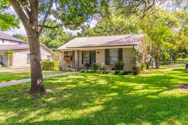 a backyard of a house with yard table and chairs