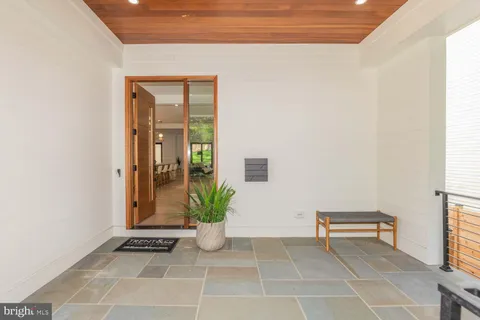 a view of an entryway with table and chair in it