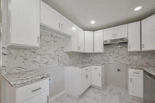 a kitchen with granite countertop white cabinets and white appliances