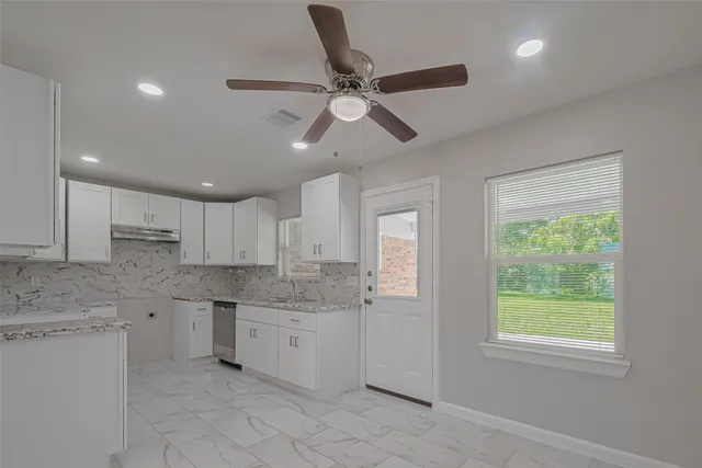a kitchen with a sink window and cabinets