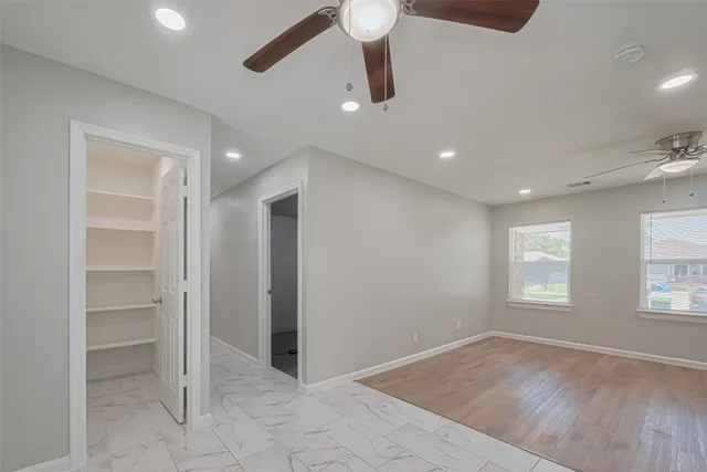 a view of an empty room with a window and wooden floor
