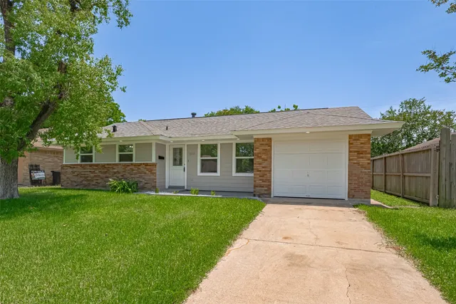 a front view of a house with a garden and yard