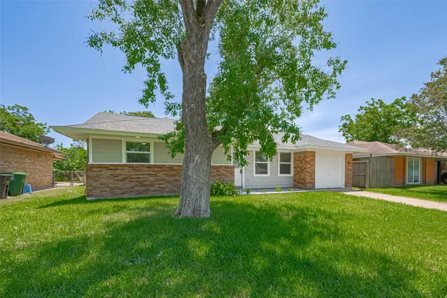a front view of a house with a garden and yard