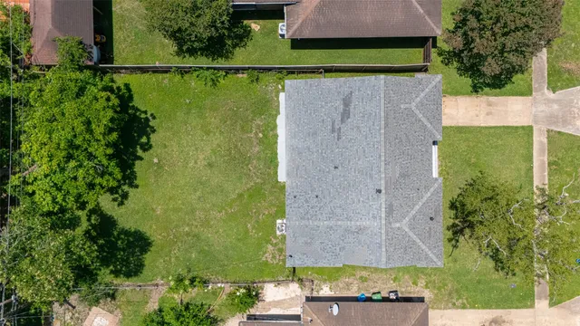a aerial view of a house next to a big yard and large trees