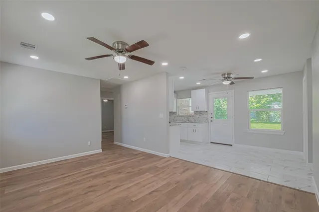 an empty room with wooden floor and a window