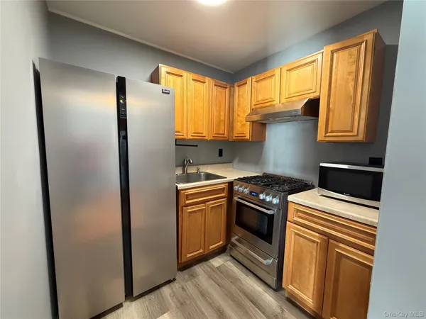 a kitchen with stainless steel appliances granite countertop a refrigerator a stove and a sink