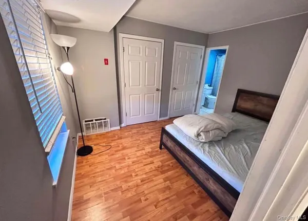 a bedroom with a bed and a large mirror on the dresser