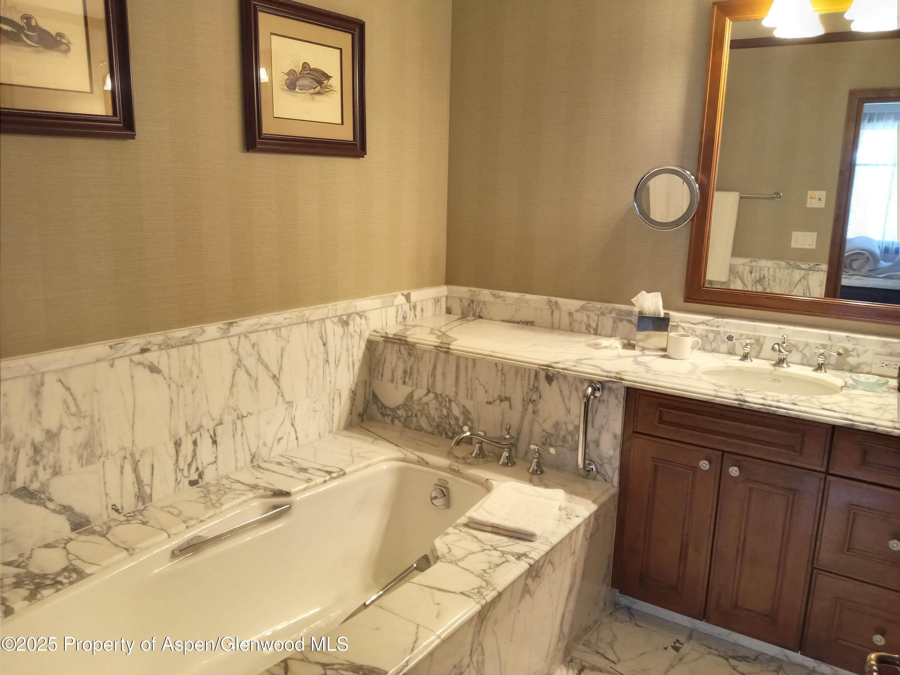 75 Prospector Road, Unit 8204 WINTER INTEREST #5 Aspen, CO 81611 - Photo 32 of 41 a bathroom with a granite countertop sink and a bathtub
