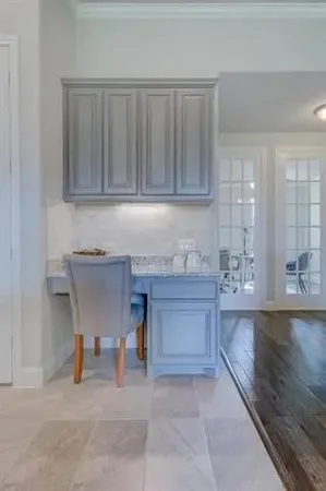a kitchen with granite countertop a sink and white cabinets