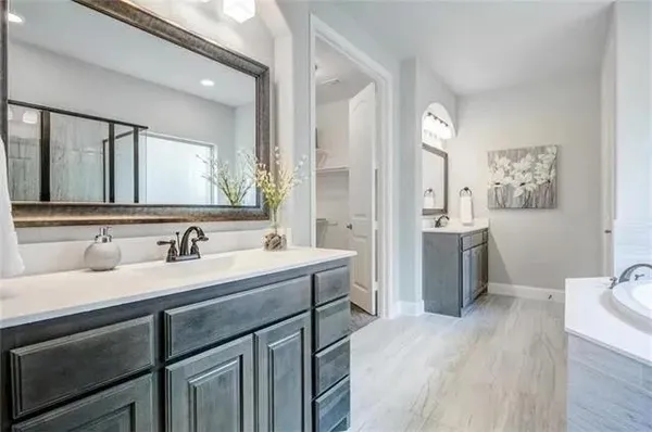 a spacious bedroom with a large bed and a chandelier