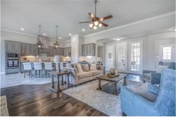 a living room with lots of furniture and kitchen view