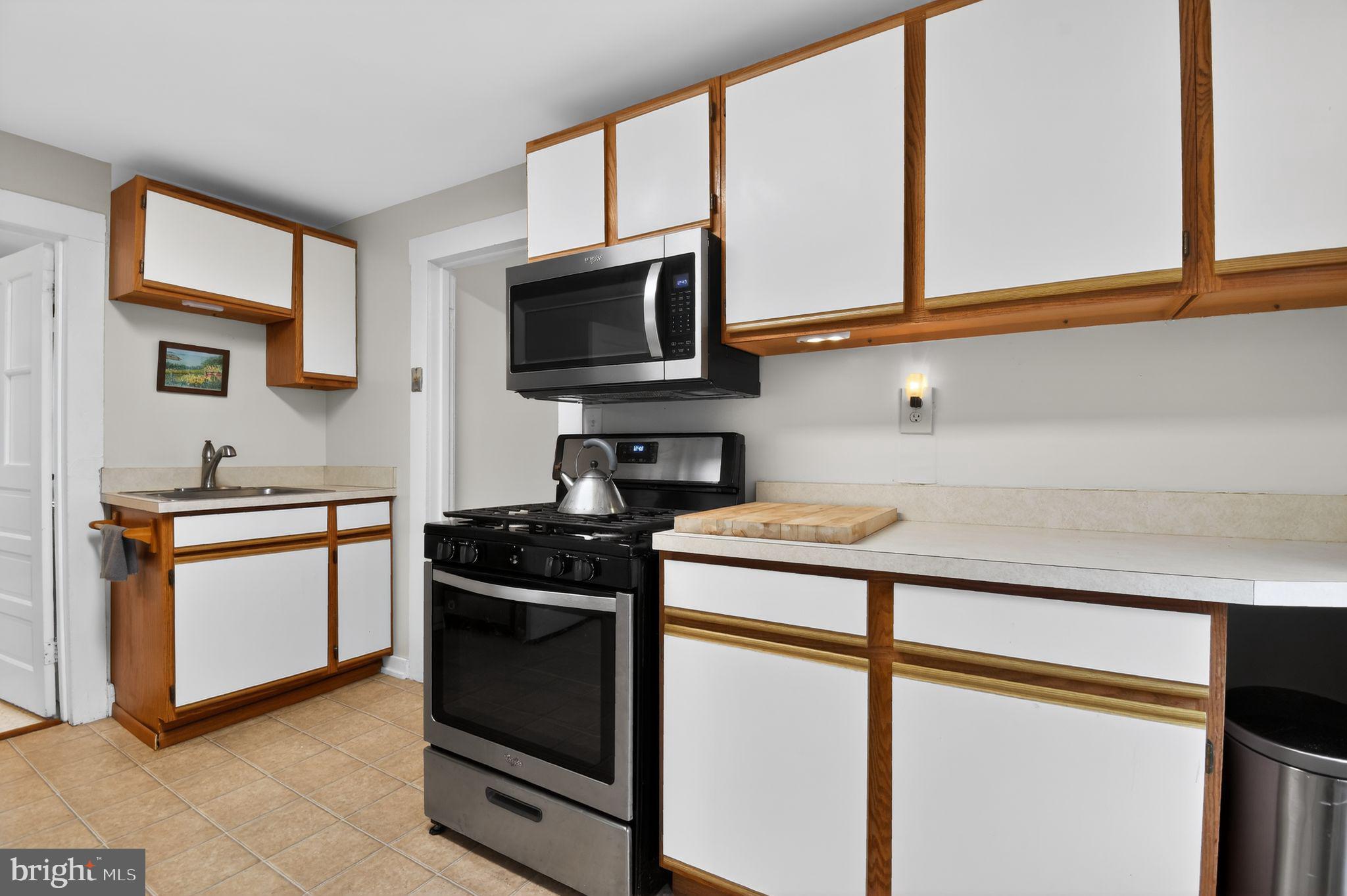 4041 7th Street North Beach, MD 20714 - Photo 11 of 35 a kitchen with stainless steel appliances granite countertop a stove microwave and sink
