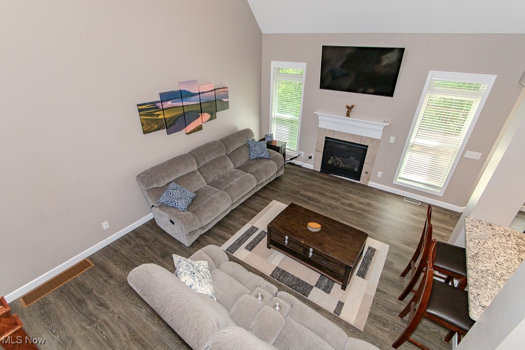 8675 Auburn Road Chardon, OH 44024 - Photo 19 of 35 Living area with dark wood-style flooring, a tile fireplace, and lofted ceiling