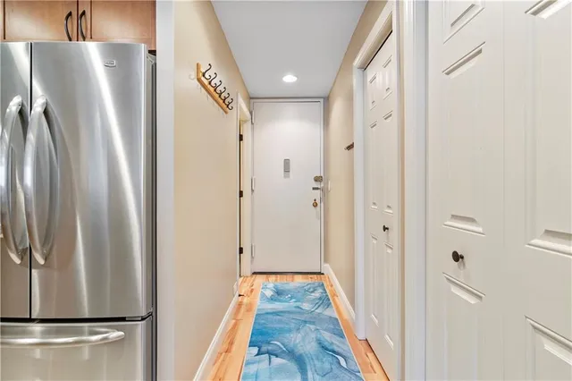 a view of hallway with wooden floor and cabinets