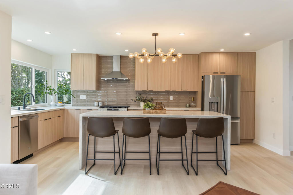 11772 Monte Leon Way Porter Ranch, CA 91326 - Photo 21 of 58 a kitchen with a dining table chairs sink and cabinets