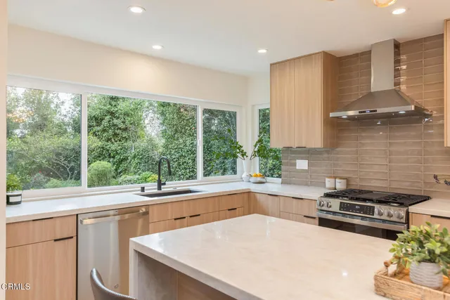 a kitchen with kitchen island granite countertop a sink and a refrigerator