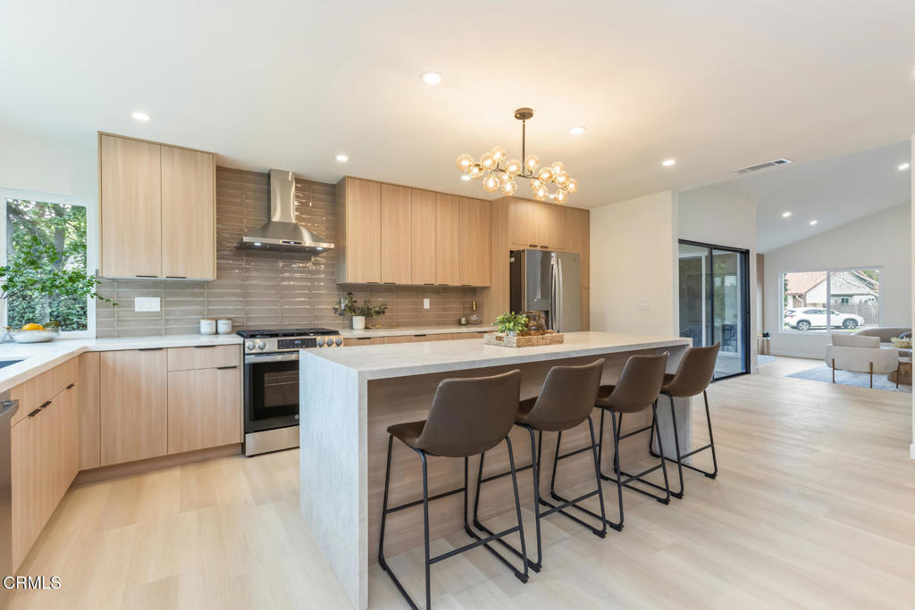 11772 Monte Leon Way Porter Ranch, CA 91326 - Photo 25 of 58 a kitchen with kitchen island granite countertop a sink and a refrigerator