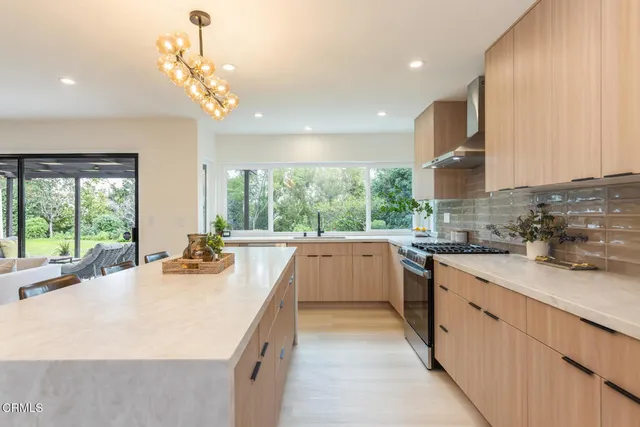a large kitchen with kitchen island a large counter top space a sink a window and appliances
