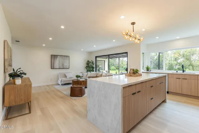 a view of a hallway with wooden floor and a bathroom