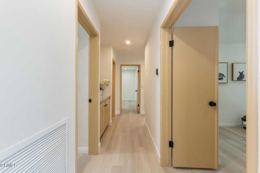 11772 Monte Leon Way Porter Ranch, CA 91326 - Photo 29 of 58 a view of a hallway with wooden floor and a bathroom